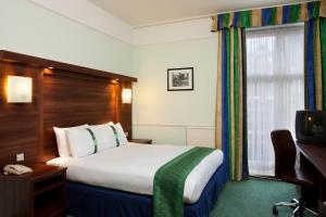 Habitación de hotel con cama y ventana en Holiday Inn London Oxford Circus, an IHG Hotel en Londres