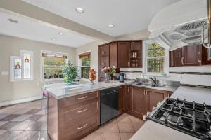 a kitchen with wooden cabinets and a stove top oven at Cozy Dunbar 3 Beds Home w/ Views in Vancouver