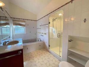 a bathroom with a shower and a sink and a tub at Cozy Dunbar 3 Beds Home w/ Views in Vancouver