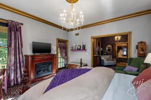 a bedroom with a bed and a fireplace and a chandelier at The Peabody House in Eureka Springs