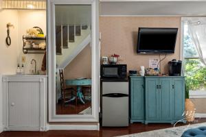 uma sala de estar com uma porta que dá para um quarto com uma televisão em The Peabody House em Eureka Springs