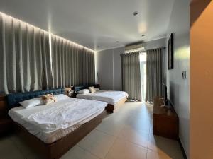 a hotel room with two beds and a television at Nancy Grand Strip Villa Imperial 1 in Vung Tau