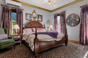 a bedroom with a bed and a clock on the wall at The Peabody House in Eureka Springs