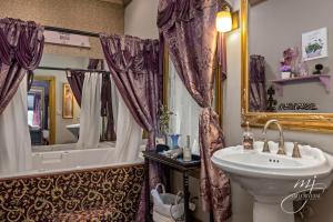 a bathroom with a sink and a toilet and a tub at The 1883 Peabody House Bed & Breakfast in Eureka Springs +20 photos