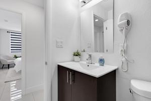 La salle de bains blanche est pourvue d'un lavabo et d'un miroir. dans l'établissement Private & Modern Home with 4 Bedrooms, à Homestead
