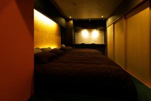 um quarto com uma cama grande num quarto escuro em MolinHotels501 -Sapporo Onsen Story- 1L2Room W-Bed4&S-6 10persons em Sapporo