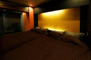 een slaapkamer met een groot bed met een gele muur bij MolinHotels501 -Sapporo Onsen Story- 1L2Room W-Bed4&S-6 10persons in Sapporo