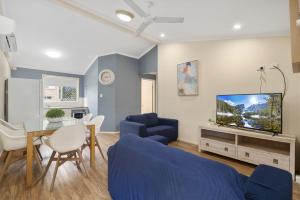 a living room with a blue couch and a tv at Caboolture Central Motor Inn, Sure Stay Collection by BW in Caboolture