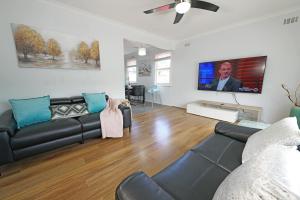 sala de estar con sofá y TV de pantalla plana en Pet-friendly Bayside 4BR Rental House near Mentone, en Parkdale