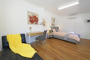 1 dormitorio con cama y escritorio con manta amarilla en Pet-friendly Bayside 4BR Rental House near Mentone en Parkdale