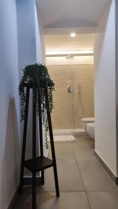 a bathroom with a stand with a plant on it at Amalò Guest House in Bari