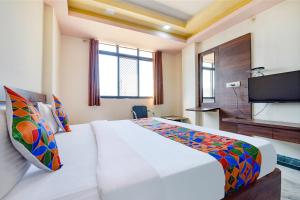 Habitación de hotel con cama y TV en FabHotel The Sunrise, en Udaipur
