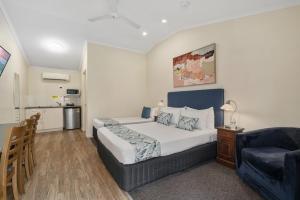 a bedroom with a bed and a chair and a couch at Caboolture Central Motor Inn, Sure Stay Collection by BW in Caboolture