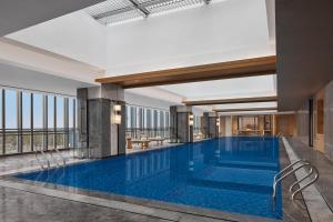 a large swimming pool in a hotel lobby at Changzhou Marriott Hotel Jintan in Changzhou