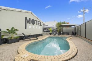 a swimming pool on a patio next to a building at Caboolture Central Motor Inn, Sure Stay Collection by BW in Caboolture