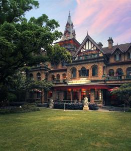 a large building with a grass yard in front of it at Shanghai Hengshan Moller Villa Hotel in Shanghai