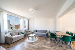 uma sala de estar com um sofá, uma mesa e cadeiras em Im Herzen Hannovers 3min City 95m² 3 Zimmer Balkon Aufzug em Hanôver