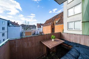 una mesa de madera en el balcón de un edificio en Im Herzen Hannovers 3min City 95m² 3 Zimmer Balkon Aufzug, en Hannover