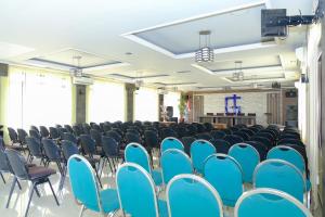 an empty room with blue chairs and a podium at Capital O 887 Green Hill Hotel And Convention Center in Jember +152 photos