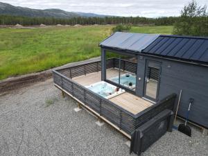 une petite maison avec une terrasse et une piscine dans l'établissement Flatmoen Natur Lodge, à Alta