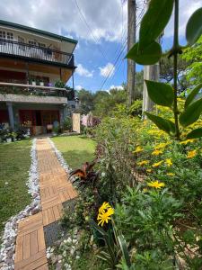 a garden with yellow flowers and a house at Moss Monterrazas in Itogon