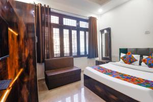 a room with a bed and a chair in it at FabExpress Royal Villas in Gwalior