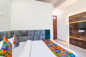 a bedroom with a bed and a tv on the wall at FabHotel Royal Vilas in Gwalior