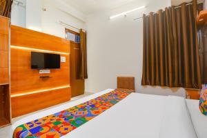 a bedroom with a bed and a tv on the wall at FabExpress Royal Villas in Gwalior