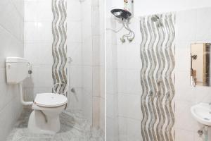 a bathroom with a toilet and a shower and a sink at FabHotel Royal Vilas in Gwalior +16 photos