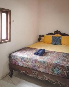 a bedroom with a bed with a wooden headboard at Notojiwo Private House 2 rooms in Jarakan