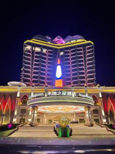 um grande edifício com uma placa à noite em Seamsak hotel em Triângulo Dourado