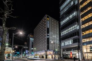 un grand bâtiment dans une ville la nuit dans l'établissement Hotel Vista Hiroshima, à Hiroshima