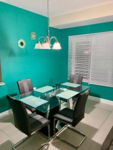 a dining room with green walls and a table and chairs at Aquamarine Resort-style Vacations in Lucea