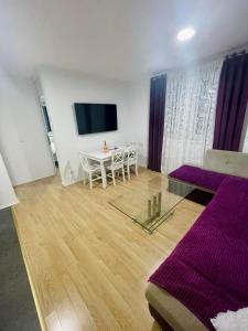 a living room with a table and a tv on the wall at MURIC Apartman 8 in Ljubljana