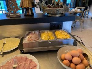 un buffet con huevos y comida en una mesa en De Kaleihoeve en Bavikhove