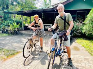 um homem e uma mulher a andar de bicicleta em Sigiri Saman Home Stay em Sigiriya