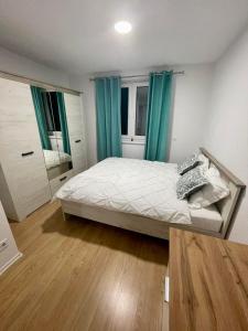 1 dormitorio con 1 cama con cortinas azules y espejo en MURIC Apartman 8, en Liubliana