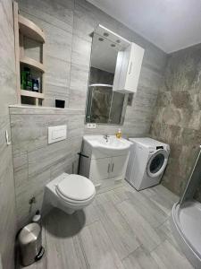 een badkamer met een wastafel en een wasmachine bij MURIC Apartman 8 in Ljubljana