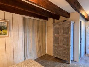 ein Schlafzimmer mit einem Schrank und einer Holzwand in der Unterkunft Nature et calme in La Chapelle-Saint-Sauveur