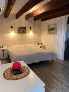 ein Schlafzimmer mit einem Bett und einem Korb auf einem Tisch in der Unterkunft Nature et calme in La Chapelle-Saint-Sauveur