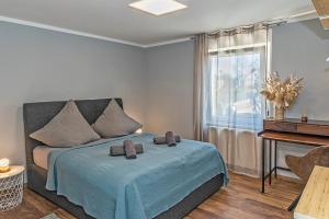 a bedroom with a bed with a blue blanket and a window at Dream Flat near the fair - Apartment in Augsburg bei der Messe in Augsburg