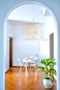 un comedor con mesa, sillas y una planta en Casa Posillipo NA en Nápoles