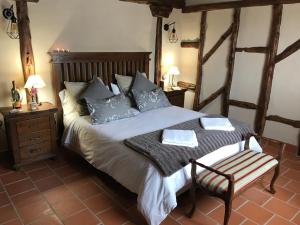 a bedroom with a large bed and a chair at Casas Rurales Hoces del Duratón in Carrascal del Río
