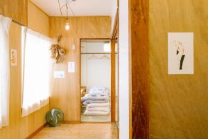 a hallway with a mirror and a pile of towels at Guesthouse RICO in Wakayama