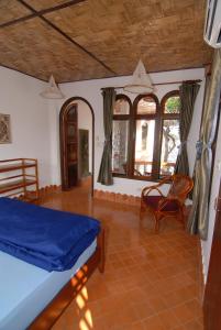 Schlafzimmer mit einem Bett, einem Stuhl und Fenstern in der Unterkunft Mut Mee Garden Guest House in Nong Khai