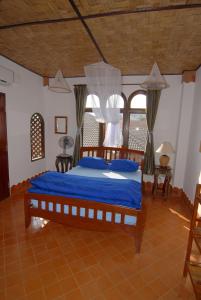 a bedroom with a large bed with blue sheets at Mut Mee Garden Guest House in Nong Khai