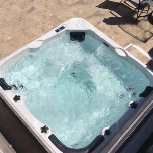 a jacuzzi tub with a table and a chair in it at Nissi49 Apartments in Ayia Napa