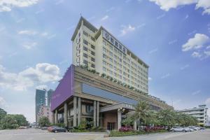 a large hotel building in a city with a parking lot at Kaijia Hotel in Bao'an