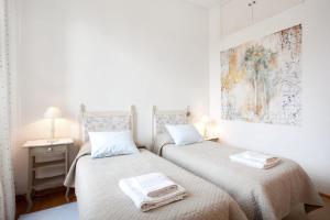 two beds in a bedroom with a painting on the wall at B&B Ondina in Rome