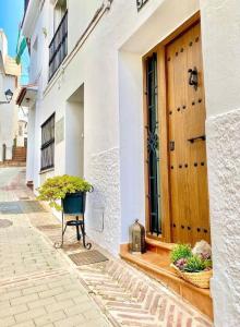 un edificio con una puerta de madera en una calle en Casa Rural Manantial de las Jaras, en Istán